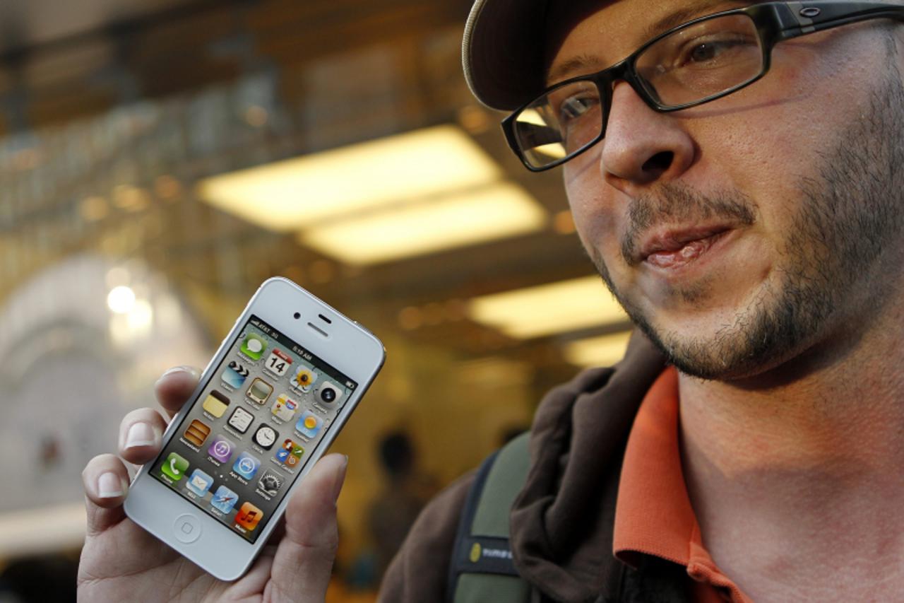'Chris Centers displays his new iPhone4S after making the purchase at Apple's flagship retail store in San Francisco, California October 14, 2011. Apple Inc's new iPhone 4S went on sale in stores a