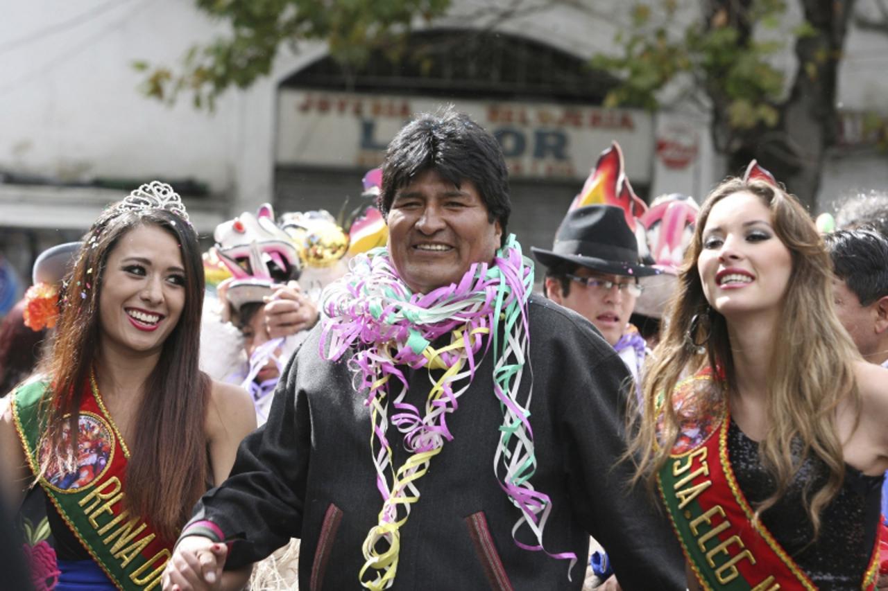 'Bolivian President Evo Morales (C) dances during carnival celebrations in front of the Presidential palace in La Paz February 8, 2013. REUTERS/Gaston Brito (BOLIVIA - Tags: POLITICS SOCIETY TPX IMAGE