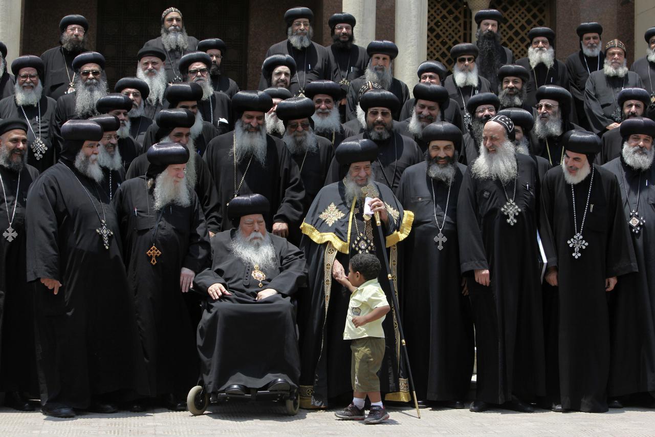Leader of Egypt's Copts, Pope Shenouda (C), holds the hand of a boy as he stands with heads and representatives of churches, before holding  a news conference at the main cathedral in Cairo June 8, 2010. An Egyptian court has ruled that two Coptic men hav