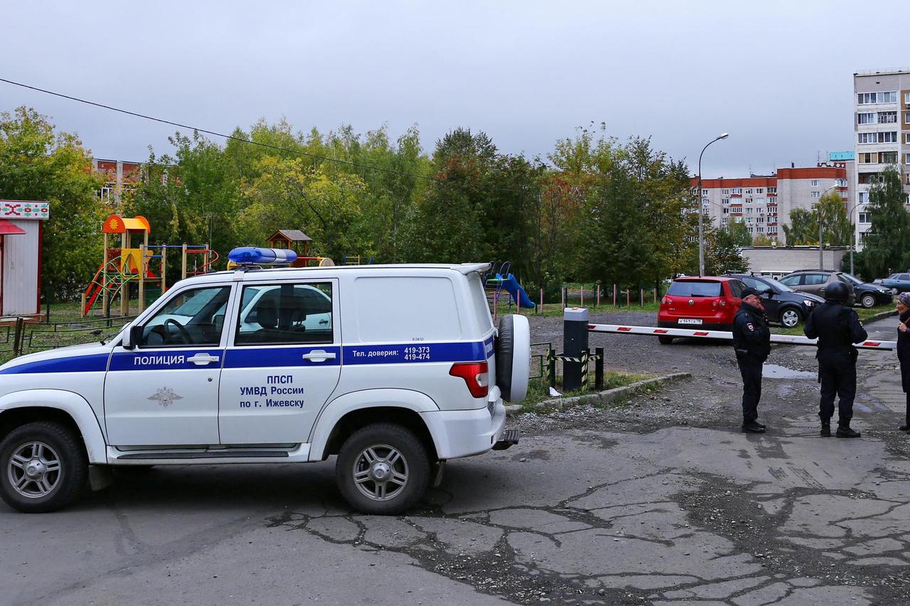 A woman talks to police officers securing area after a school shooting in Izhevsk