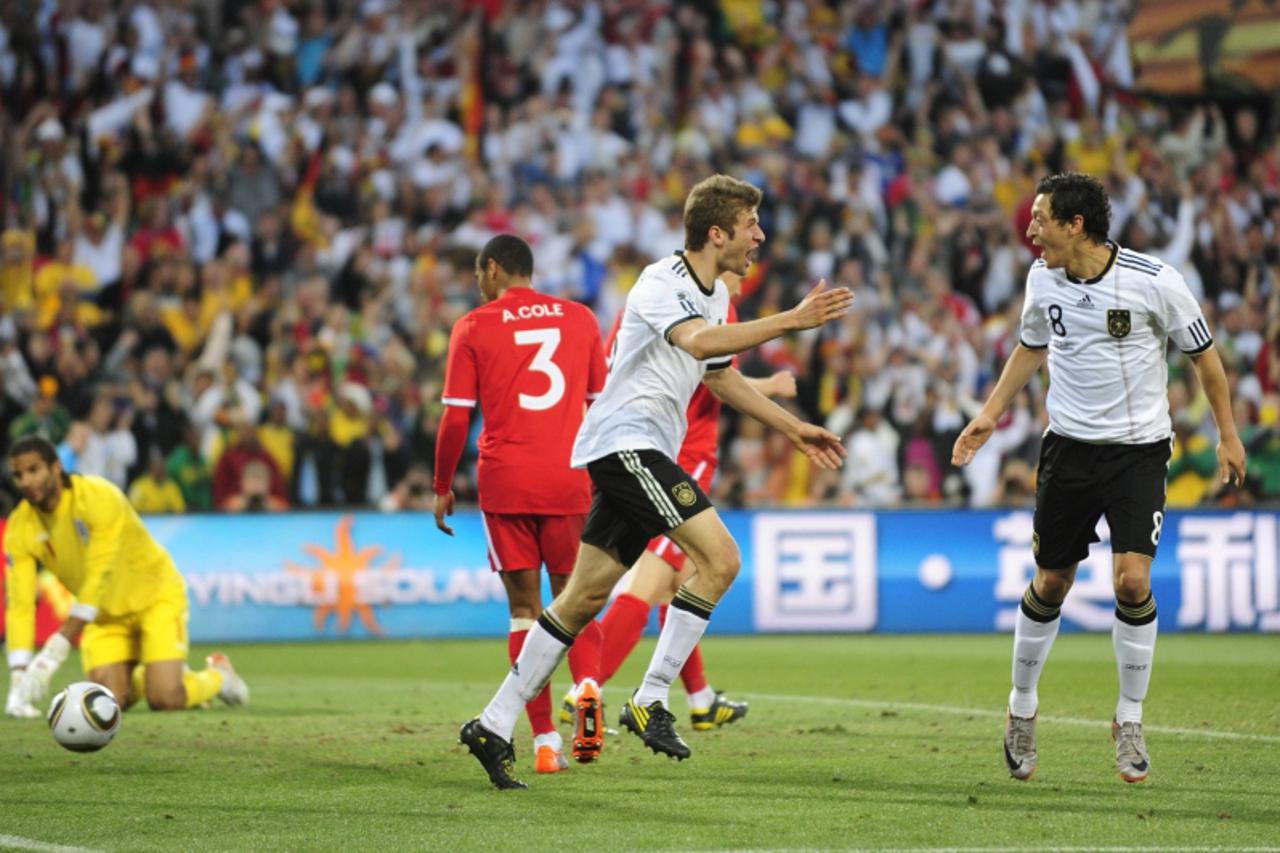 'Germany\'s midfielder Thomas Mueller (c) celebrates with team mate Germany\'s midfielder Mesut Ozil  after scoring a fourth goal during the 2010 World Cup round of 16 football match Germany vs. Engla