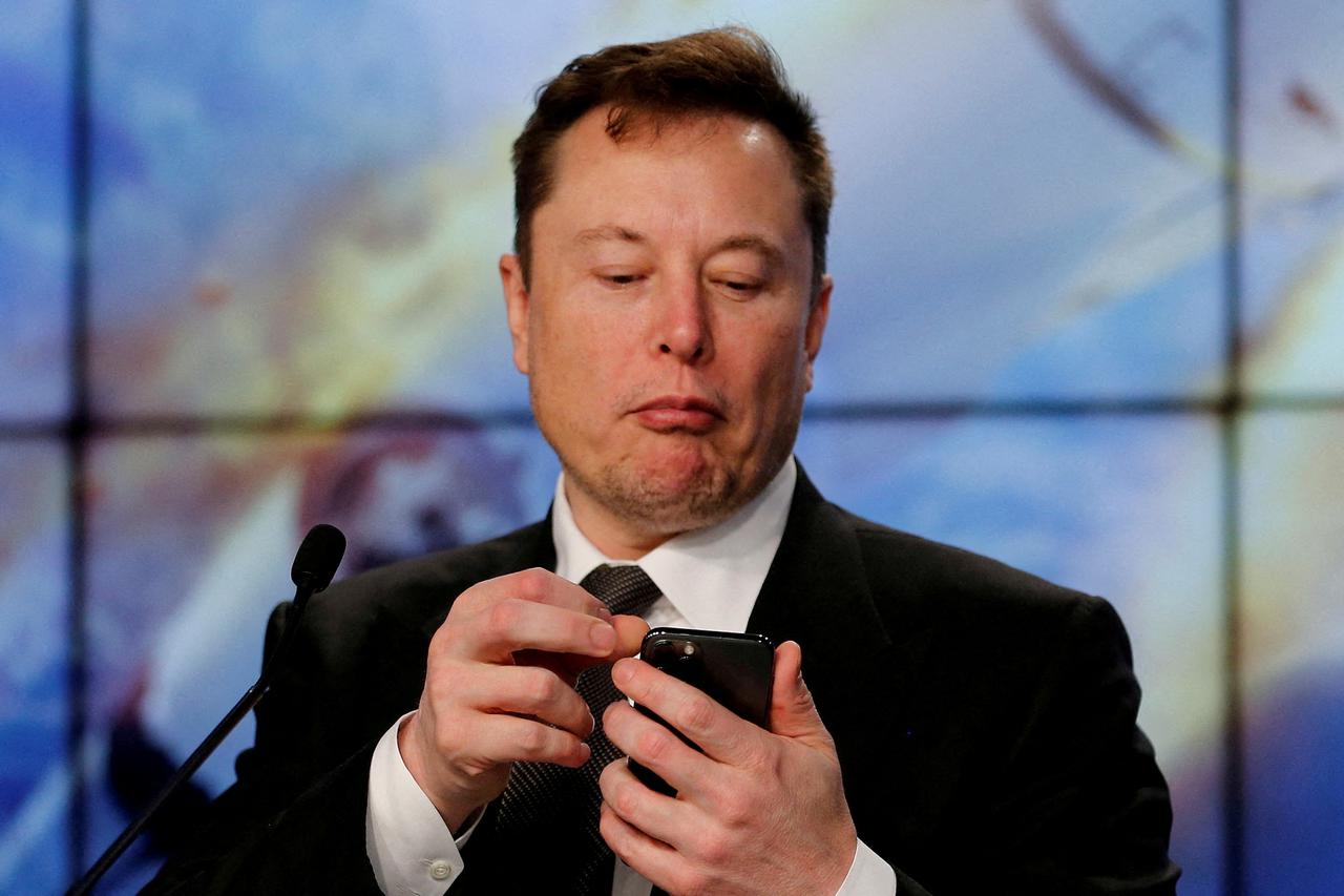 FILE PHOTO: Elon Musk looks at his mobile phone during a post-launch news conference to discuss the  SpaceX Crew Dragon astronaut capsule in-flight abort test at the Kennedy Space Center