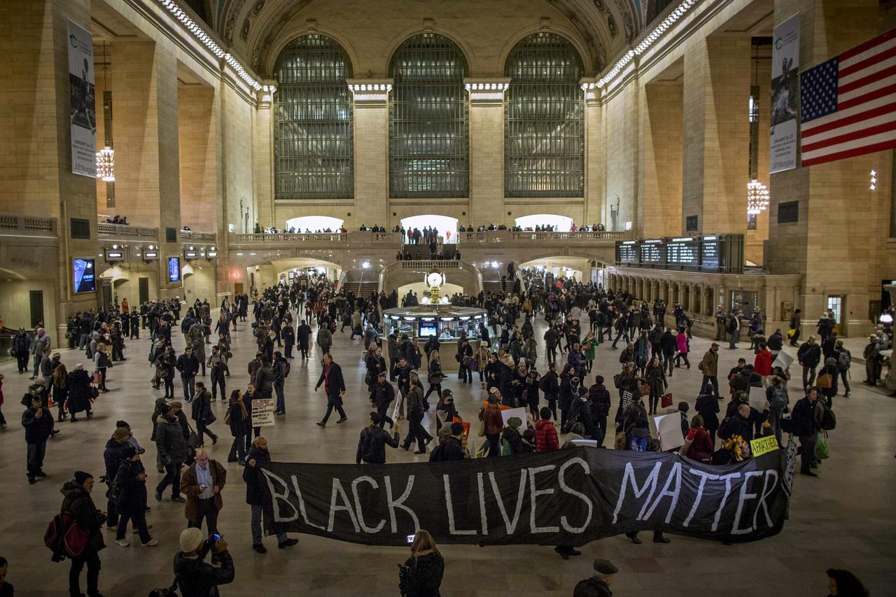 Demonstrators carry a banner through Grand Central Station during a protest against police violence towards minorities in New York January 15, 2015. The protests were organized to coincide with Martin Luther King's birthday and have been ongoing in New Yo
