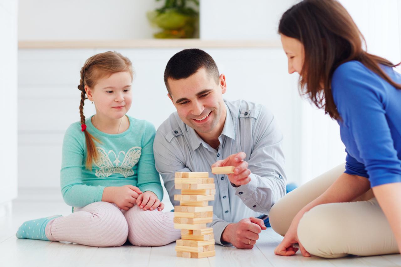 Obitelj s djetetom slaže kocke, igra