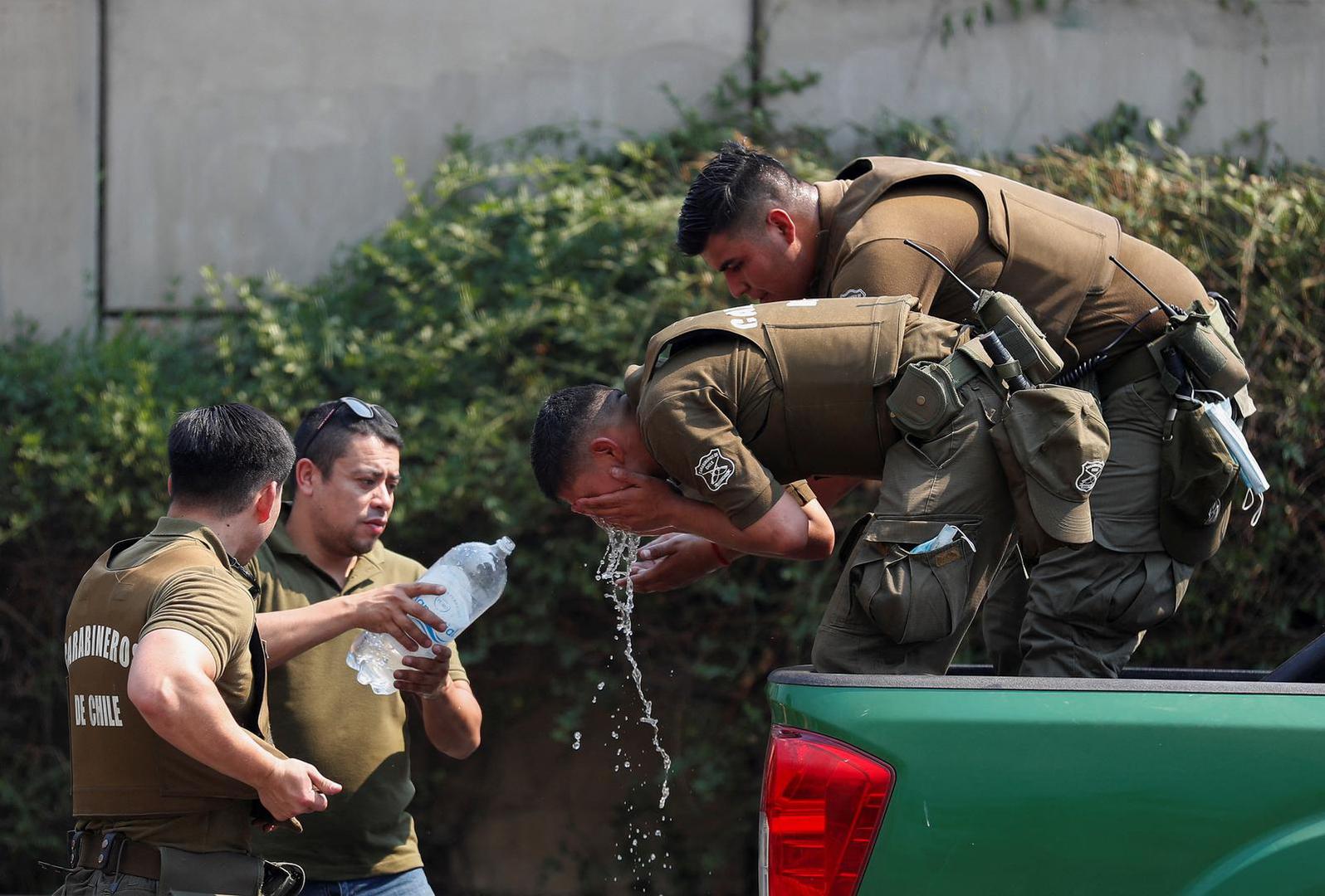 Police officers drink water and refresh themselves amid the spread of wildfires in Vina del Mar, Chile, February 3, 2024. REUTERS/Rodrigo Garrido Photo: RODRIGO GARRIDO/REUTERS