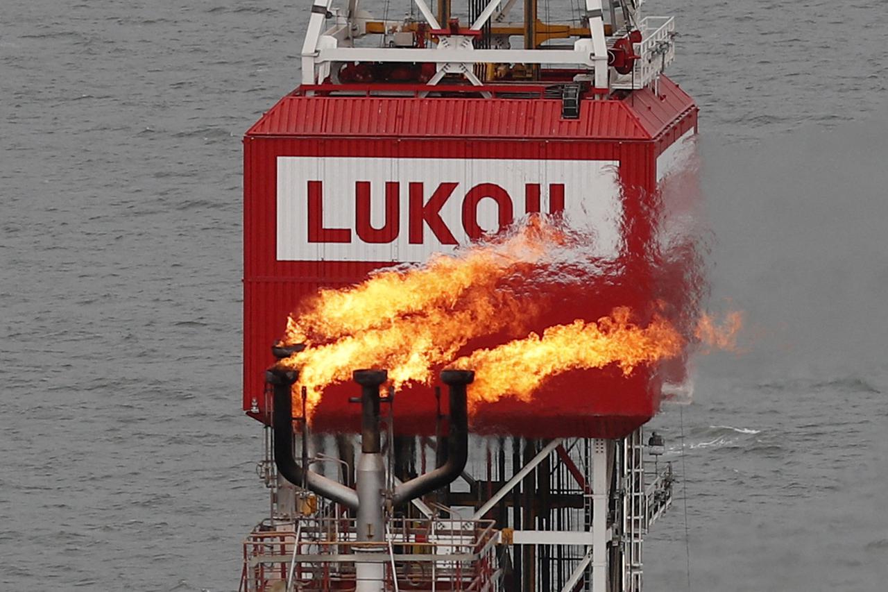 FILE PHOTO: A gas torch is seen next to the Lukoil company sign at the Filanovskogo oil platform in the Caspian Sea