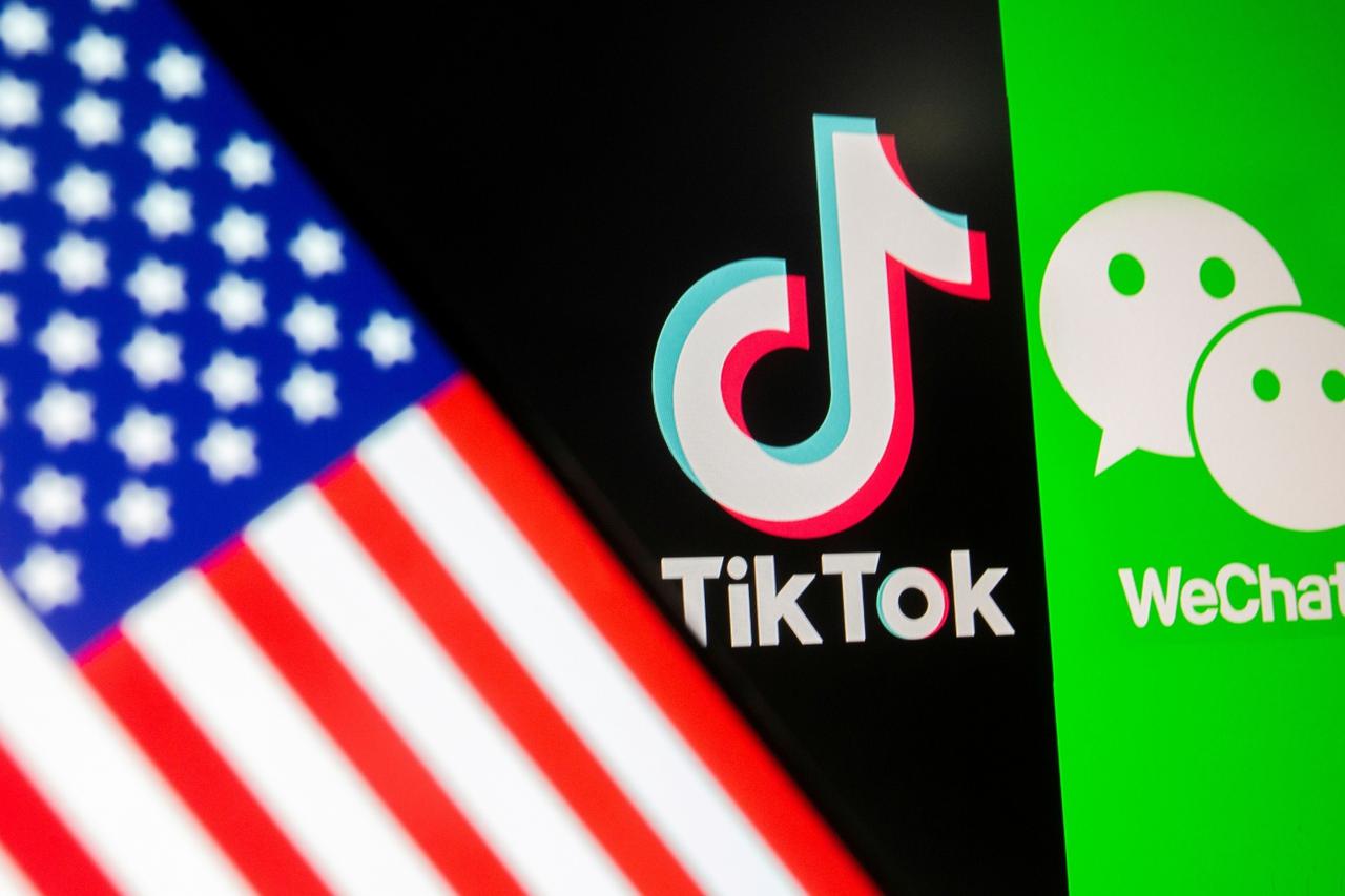 FILE PHOTO: U.S. flag is seen on a smartphone in front of displayed Tik Tok and WeChat logos in this illustration