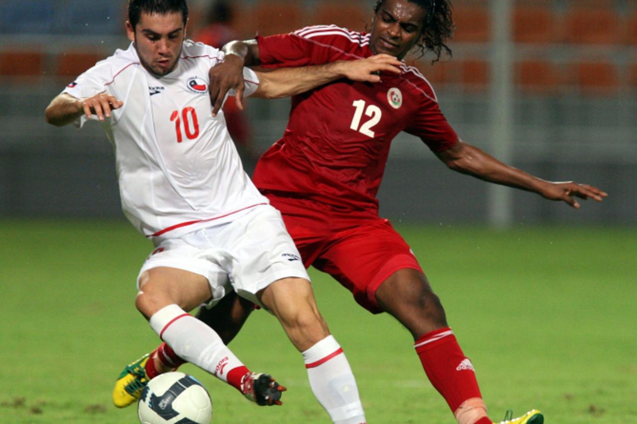 \'Omani player Ahmed Mubarak (R) vies with Pedro Morales (L) Of Chile during their friendly football match in Muscat on October 12, 2010. AFP PHOTO/MOHAMMED MAHJOUB\'