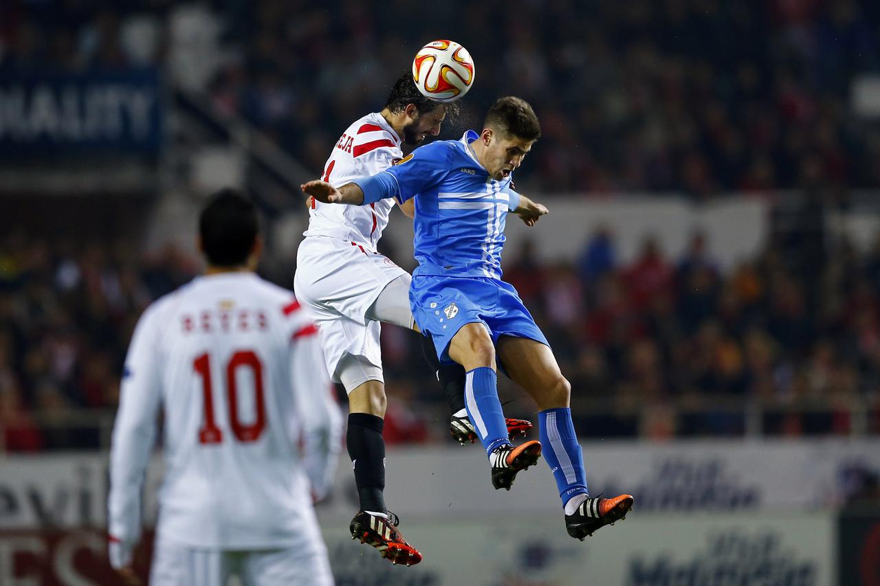 Sevilla's Nicolas Martin Pareja (L) and Rijeka's Andrej Kramaric jump for the ball during their Europa League Group G soccer match in Seville, December 11, 2014. REUTERS/Marcelo del Pozo (SPAIN - Tags: SPORT SOCCER)