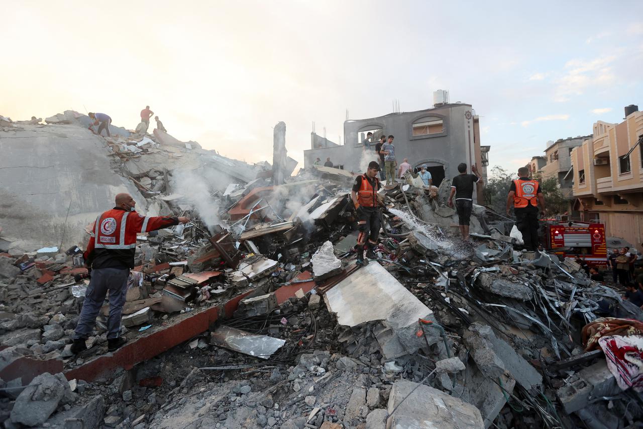 Palestinians search for casualties at the site of Israeli strikes on a residential building