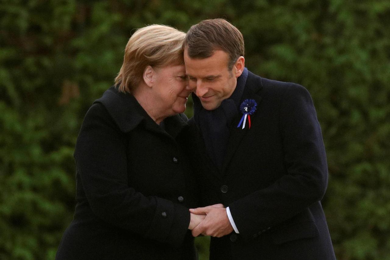 FILE PHOTO: French President Emmanuel Macron and German Chancellor Angela Merkel hug after unveiling a plaque in the Clairiere of Rethondes during a commemoration ceremony for Armistice Day, 100 years after the end of the First World War, in Compiegne