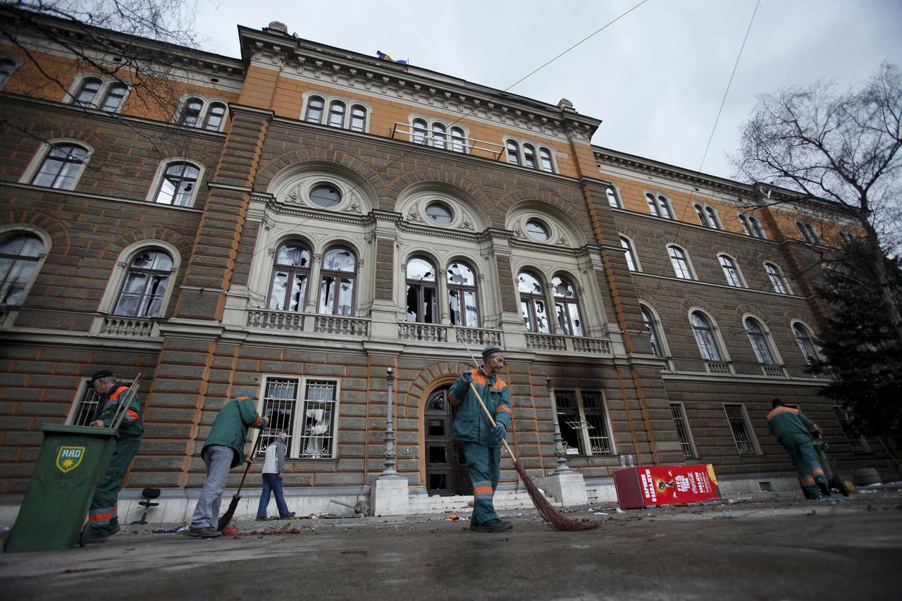 Workers clean the front of a government building that was destroyed during a protest in Sarajevo February 8, 2014. Protesters across Bosnia set fire to government buildings and fought with riot police on Friday as long-simmering anger over lack of jobs an