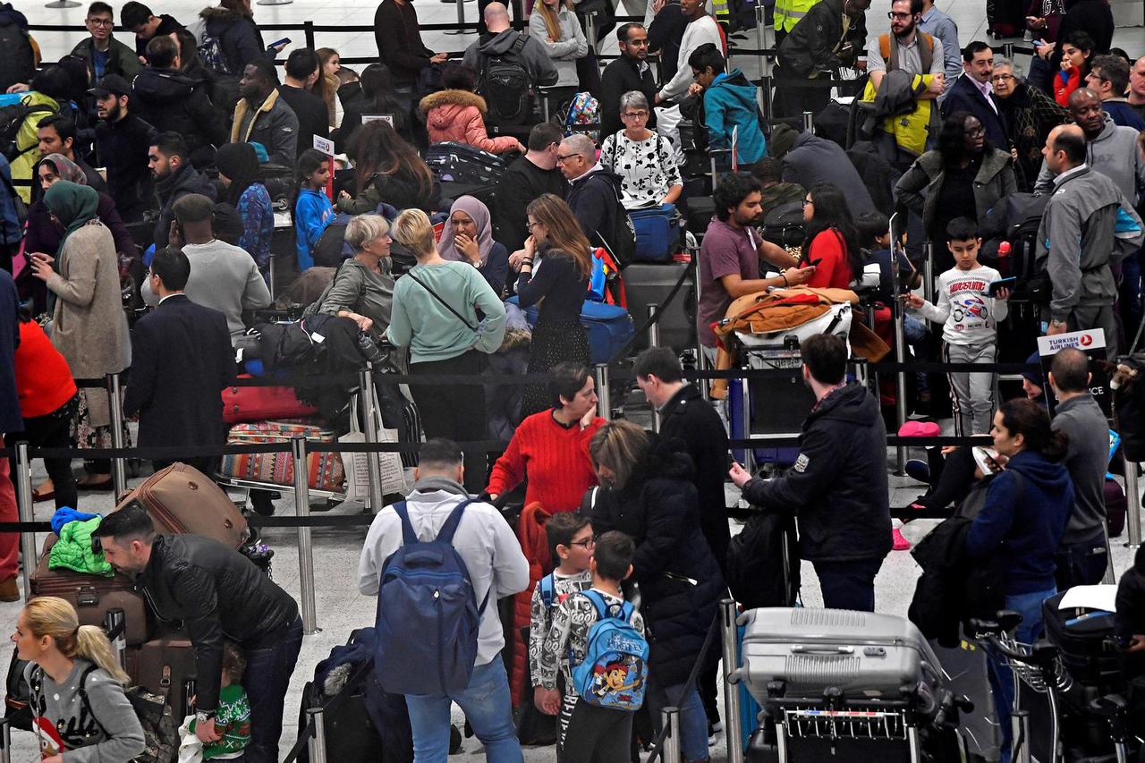 FILE PHOTO: Passengers wait in the queue for check-in in the South Terminal building at Gatwick Airport, in Gatwick