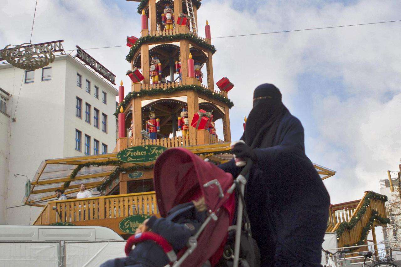 A woman in a Niqab walks by a Christmas Pyramid in downtown Hanover, Germany November 18, 2015, the day after a soccer match between Germany and Netherlands was cancelled due to security concerns.   REUTERS/Axel Schmidt