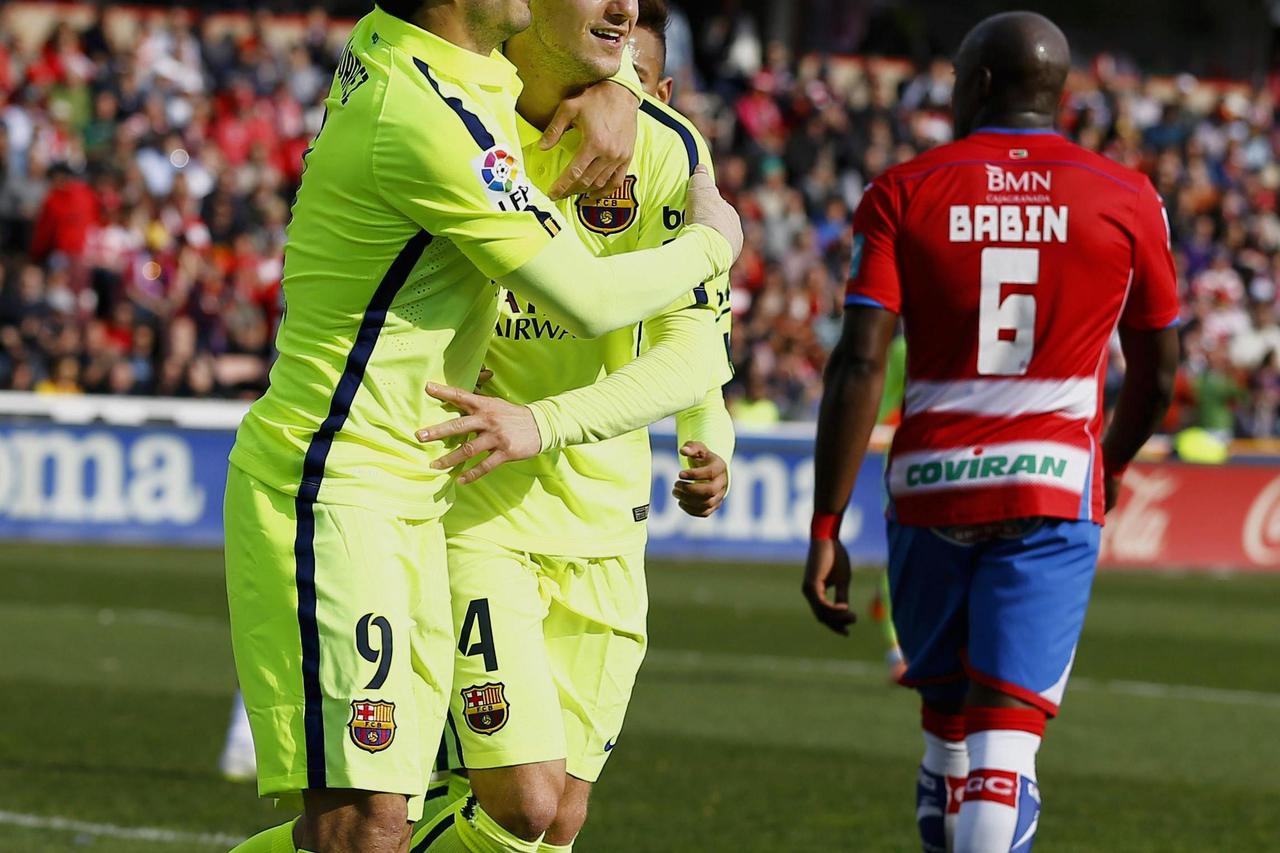 Barcelona's Ivan Rakitic (C) is congratulated by teammate Luis Suarez after scoring a goal against Granada during their Spanish first division soccer match at Nuevo Los Carmenes stadium in Granada February 28, 2015. REUTERS/Marcelo del Pozo (SPAIN - Tags: