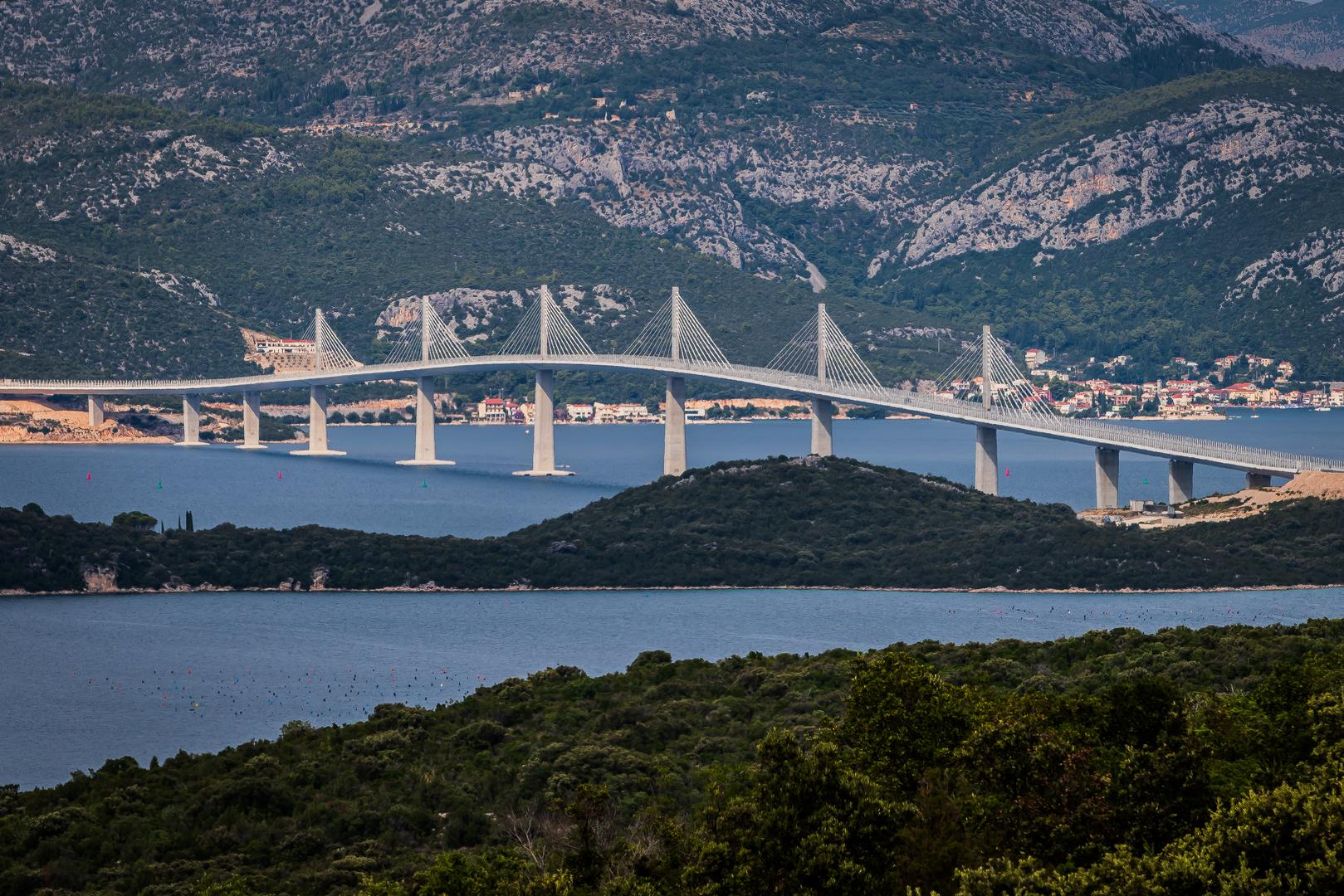 Most je ovješenog tipa, ukupne duljine 2404 metra sa šest glavnih stupova i trinaest raspona od čelika duljine od 72 do 285 metara. Visinom od 55 metara udovoljilo se zahtjevu Bosne i Hercegovine za osiguranjem nesmetanog prolaska brodova do Neuma.