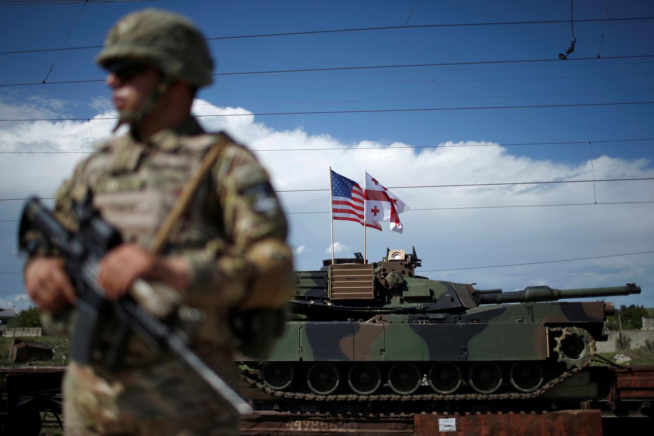 A Georgian serviceman stands in front of U.S. M1A2 
