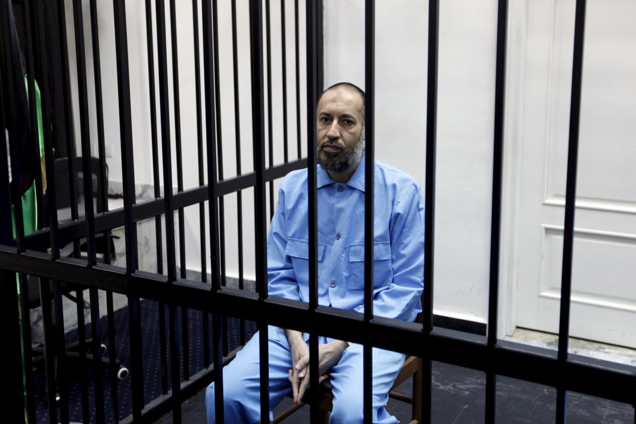 FILE PHOTO: Saadi Gaddafi, son of Muammar Gaddafi, sits behind bars during a hearing at a courtroom in Tripoli, Libya