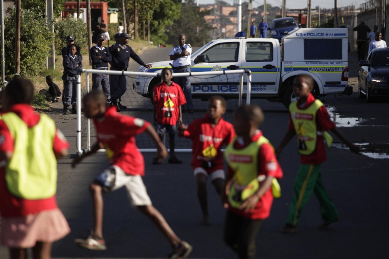 'Children play soccer as the South African Police Service keeps a watchful eye during the Kia Street Soccer League in Lamontville, near Durban, April 23, 2010. More than 3 000 children from impoverish