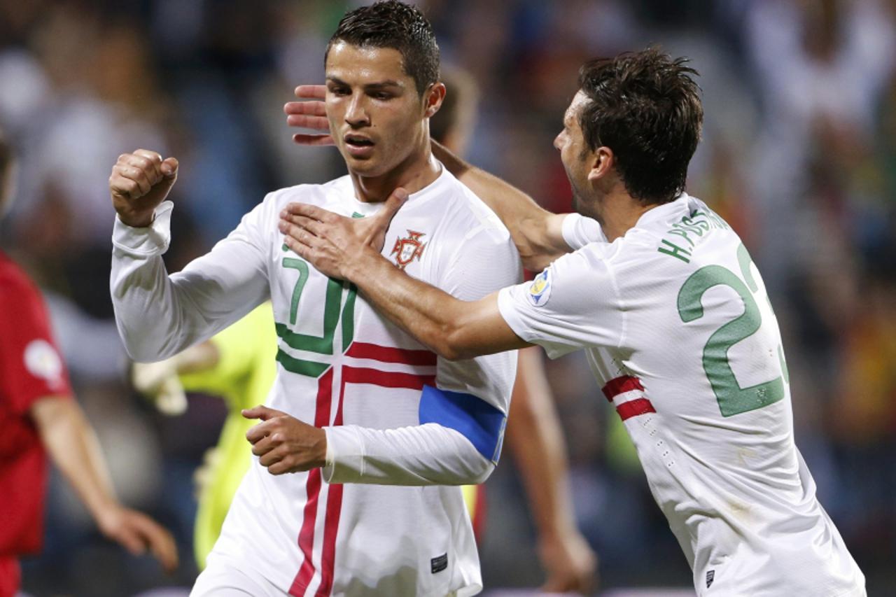 'Portugal\'s Cristiano Ronaldo (L) celebrates his goal with team mate Helder Postiga (R) during their 2014 World Cup Qualifying match against Luxembourg in Luxembourg September 7, 2012.         REUTER
