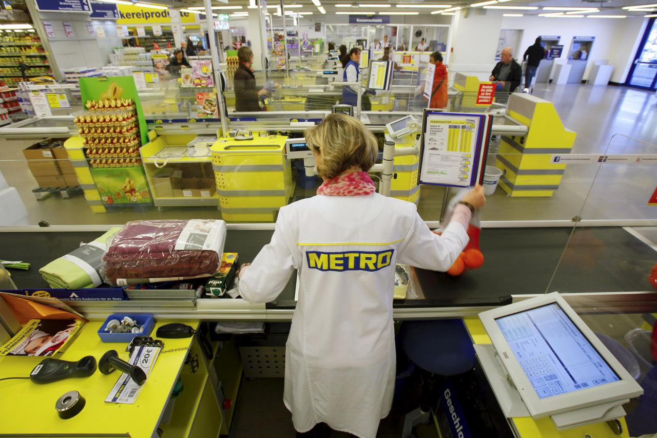 A cashier works at one of the top three cash and carry markets of Metro AG in Sankt Augustin near Bonn, Germany in this March 18, 2013 file photo. German retailer Metro is expected to report full year results this week.   REUTERS/Wolfgang Rattay/FilesGLOB