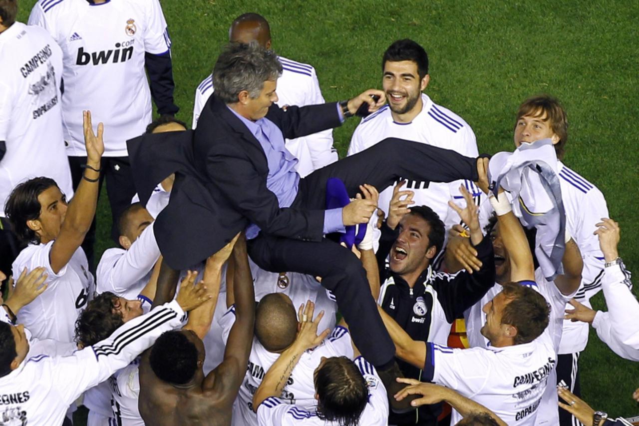 'Real Madrid\'s coach Jose Mourinho is thrown into the air by players after winning the King\'s Cup final soccer match against Barcelona at Mestalla stadium in Valencia April 20, 2011.     REUTERS/RFE