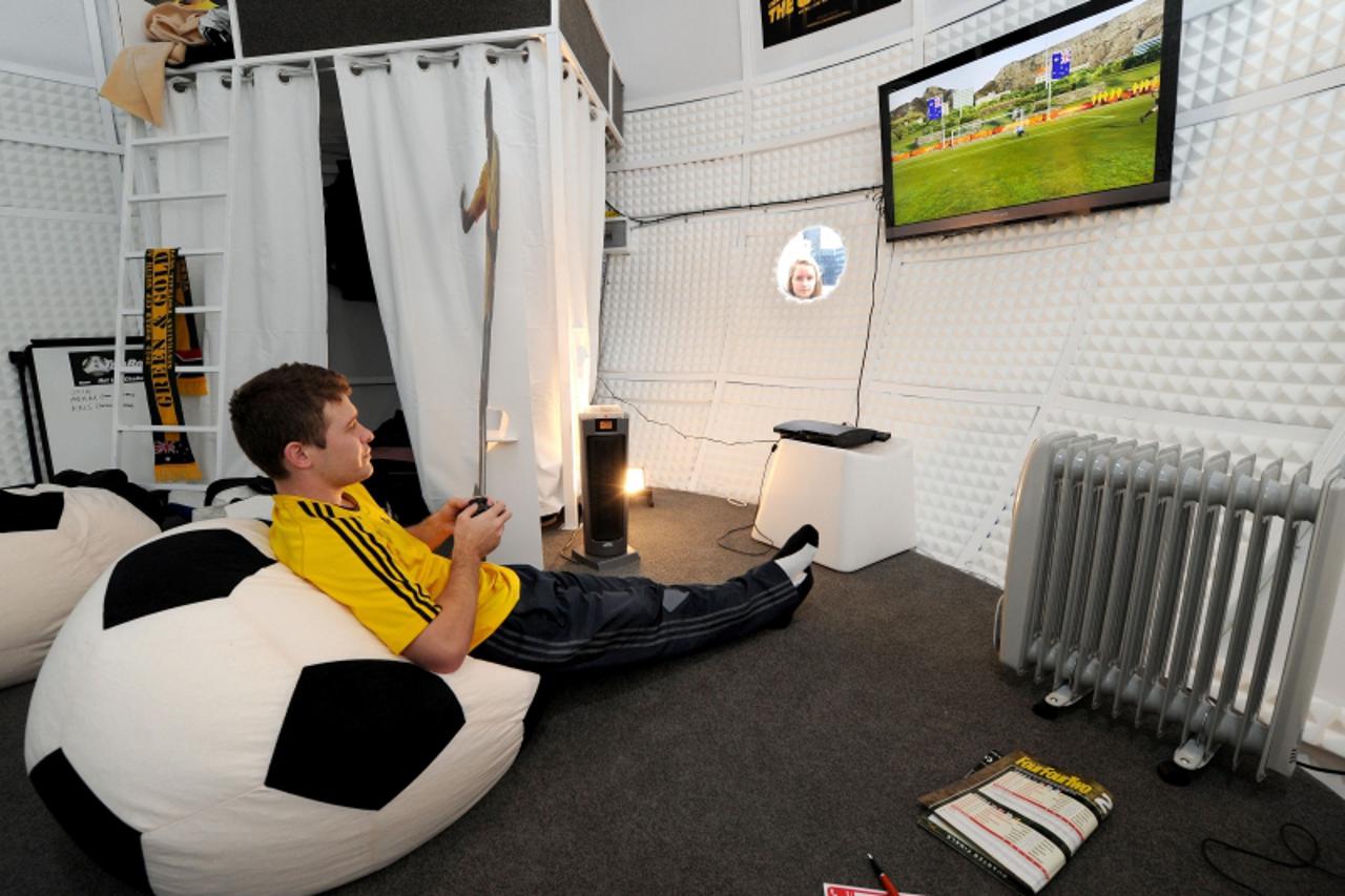 \'Competition winner Adam Santarossa watches the TV screen as he spends 31 days in a giant replica Jabulani World Cup ball, watching all 64 games from South Africa, in Melbourne on June 23, 2010.  San