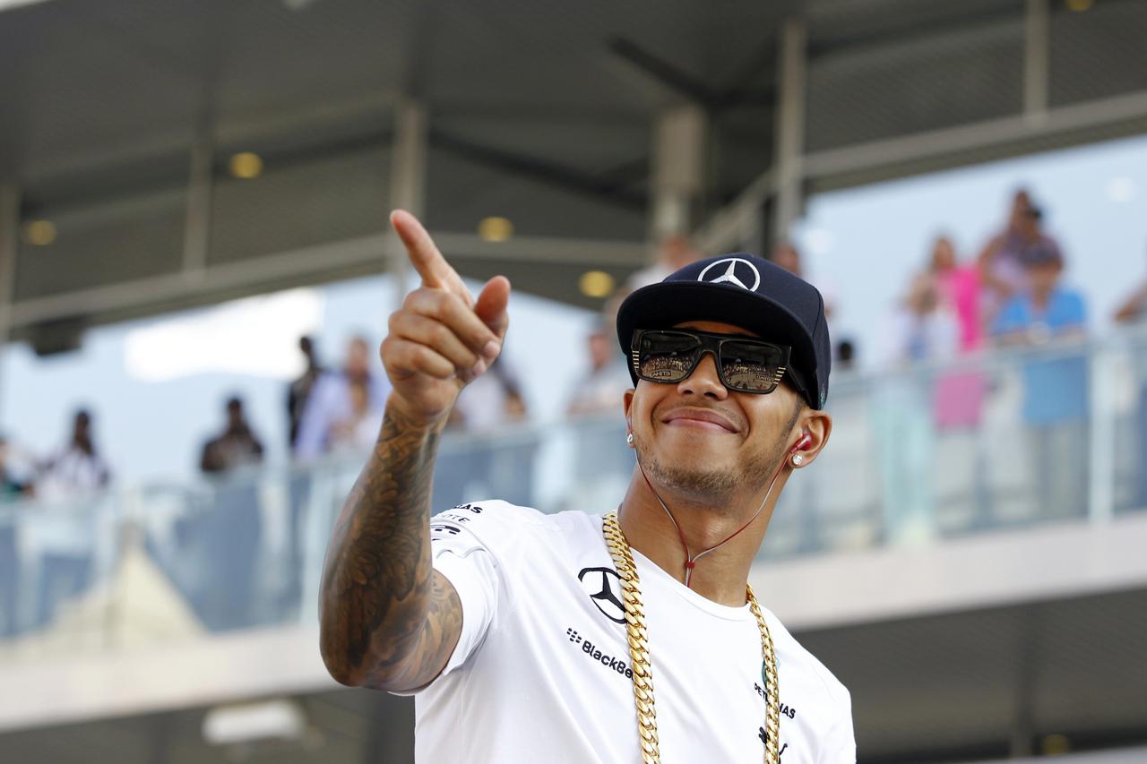 Mercedes Formula One driver Lewis Hamilton of Britain gestures at fans after the group photo at the Abu Dhabi F1 Grand Prix at the Yas Marina circuit in Abu Dhabi November 23, 2014.  REUTERS/Hamad I Mohammed (UNITED ARAB EMIRATES - Tags: SPORT MOTORSPORT 