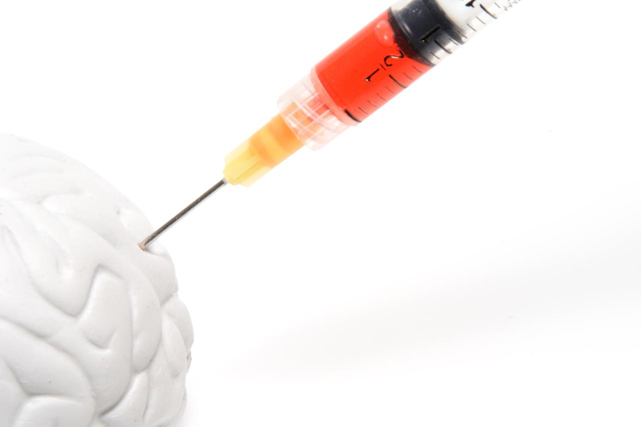 A syringe injecting medication into a brain.