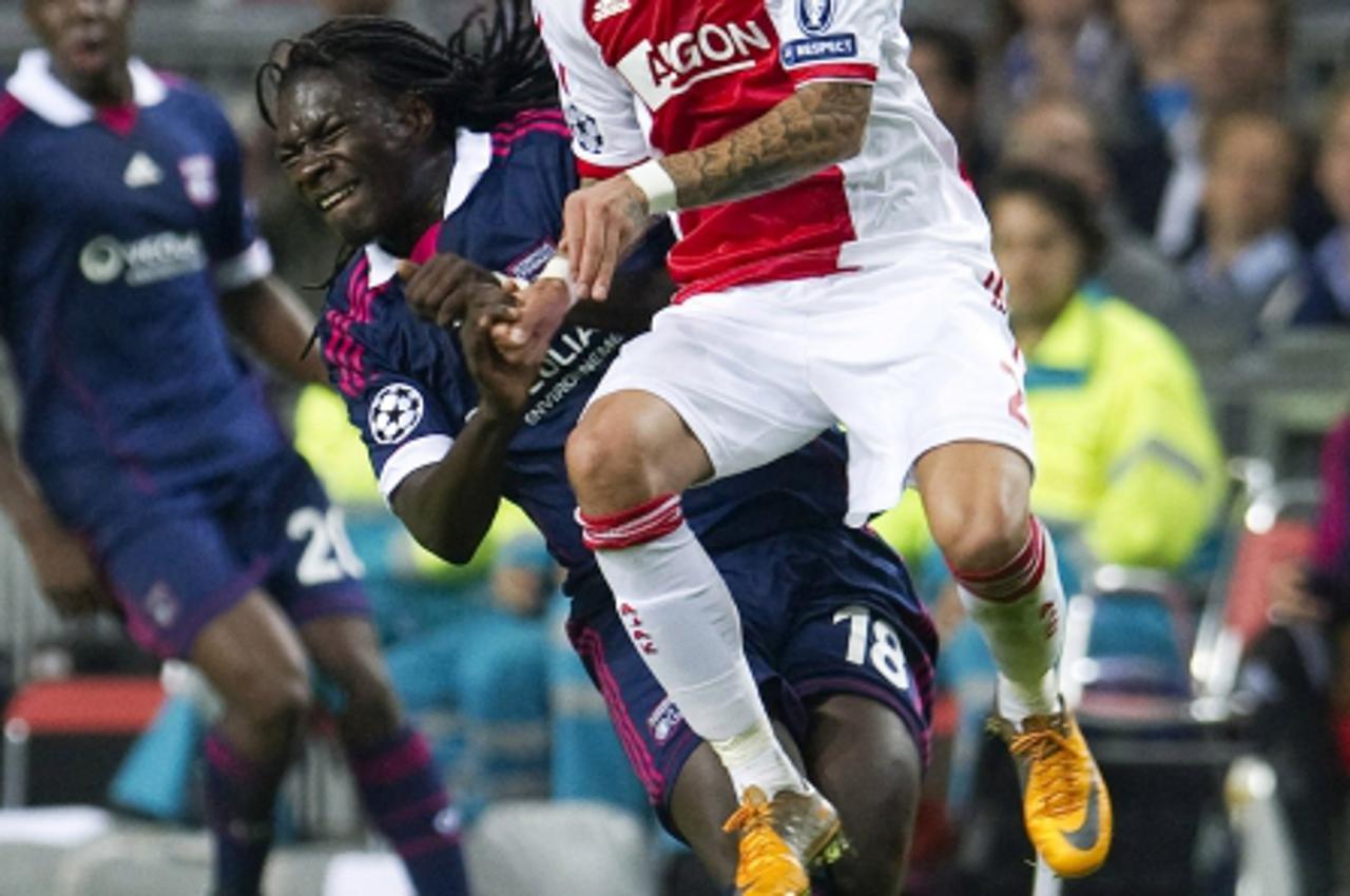 'Ajax Amsterdam\'s Gregory van der Wiel (R)  fights for the ball with Bafetimbi Gomis of Olympique Lyon  during their Champions  League Group D soccer match in Amsterdam,  September 14, 2011. REUTERS/