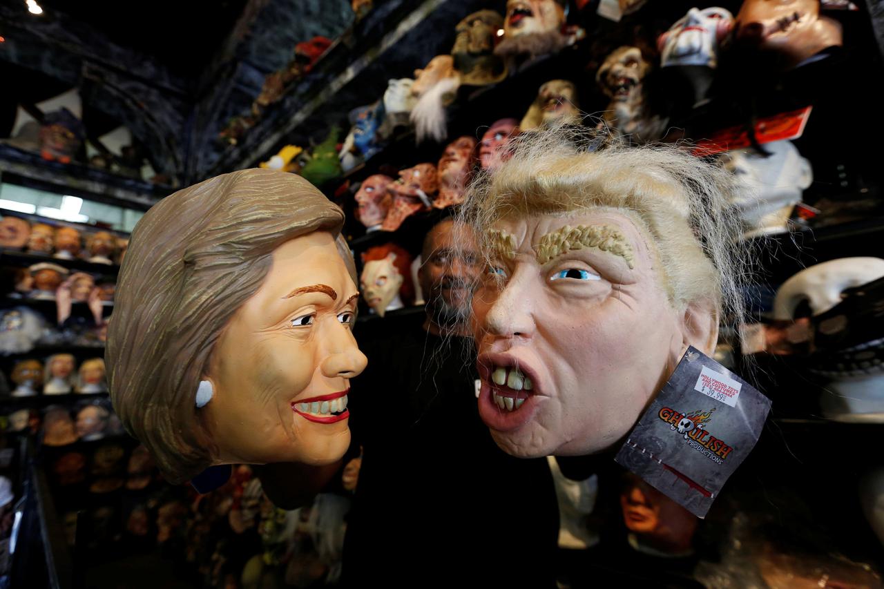 An employee holds up masks depicting Democratic presidential nominee Hillary Clinton and Republican presidential nominee Donald Trump at Hollywood Toys  Costumes in Los Angeles, California U.S., October 26, 2016.   REUTERS/Mario Anzuoni     TPX IMAGES OF 