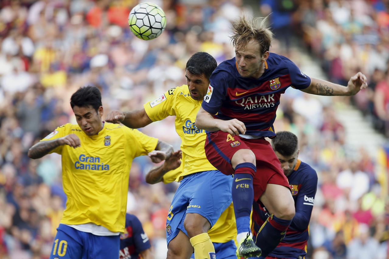 Barcelona's Ivan Rakitic (4) heads the ball past Las Palmas' Aythami Artiles (C) and Sergio Ezequiel Araujo during their Spanish first division soccer match at Camp Nou stadium in Barcelona, Spain, September 26, 2015. REUTERS/Sergio Perez