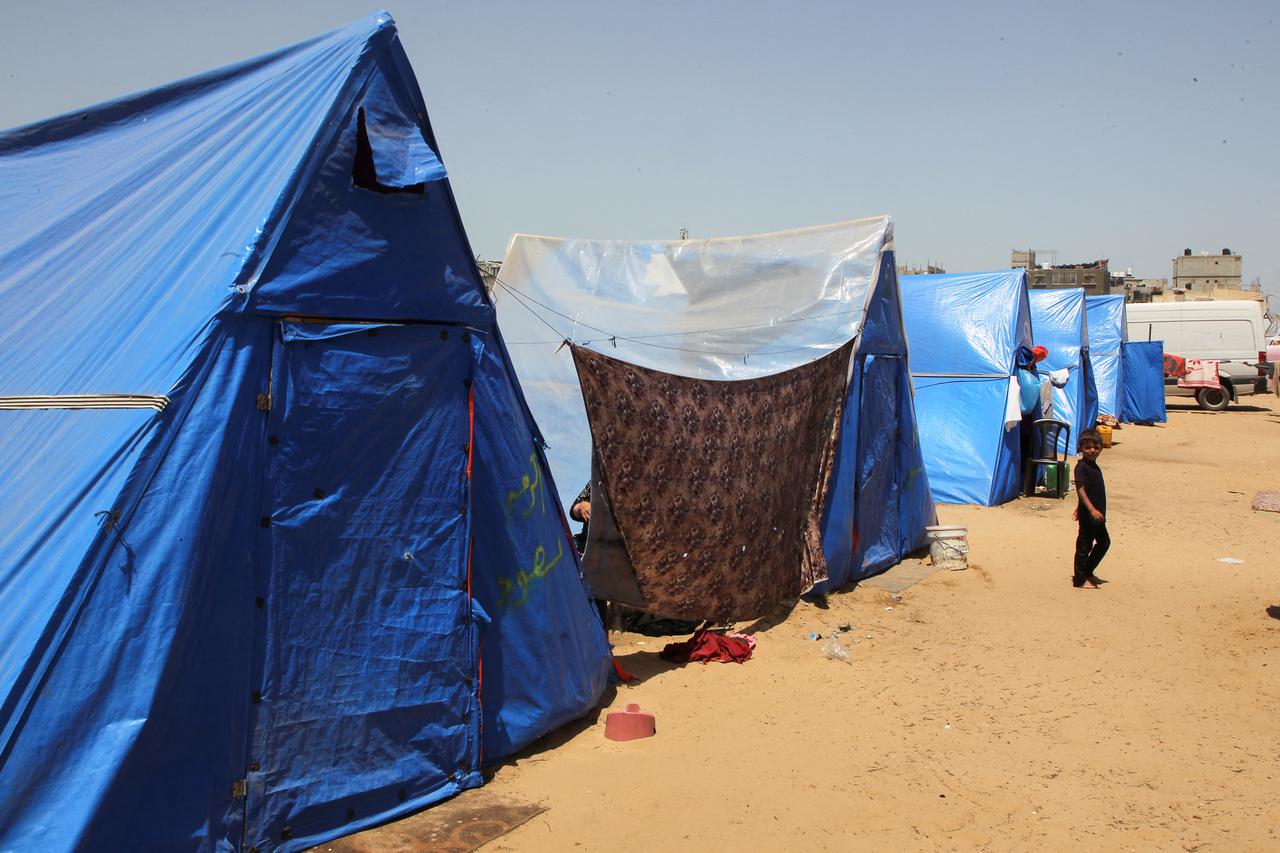 Displaced Palestinians, who fled their houses due to Israeli strikes, shelter at a tent camp in Rafah