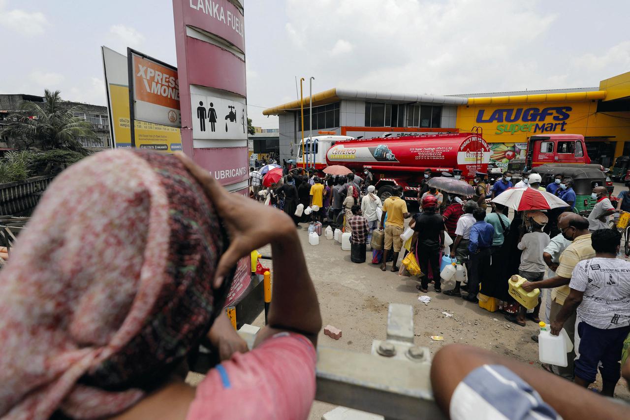 People queue to buy kerosene at a fuel station in Colombo