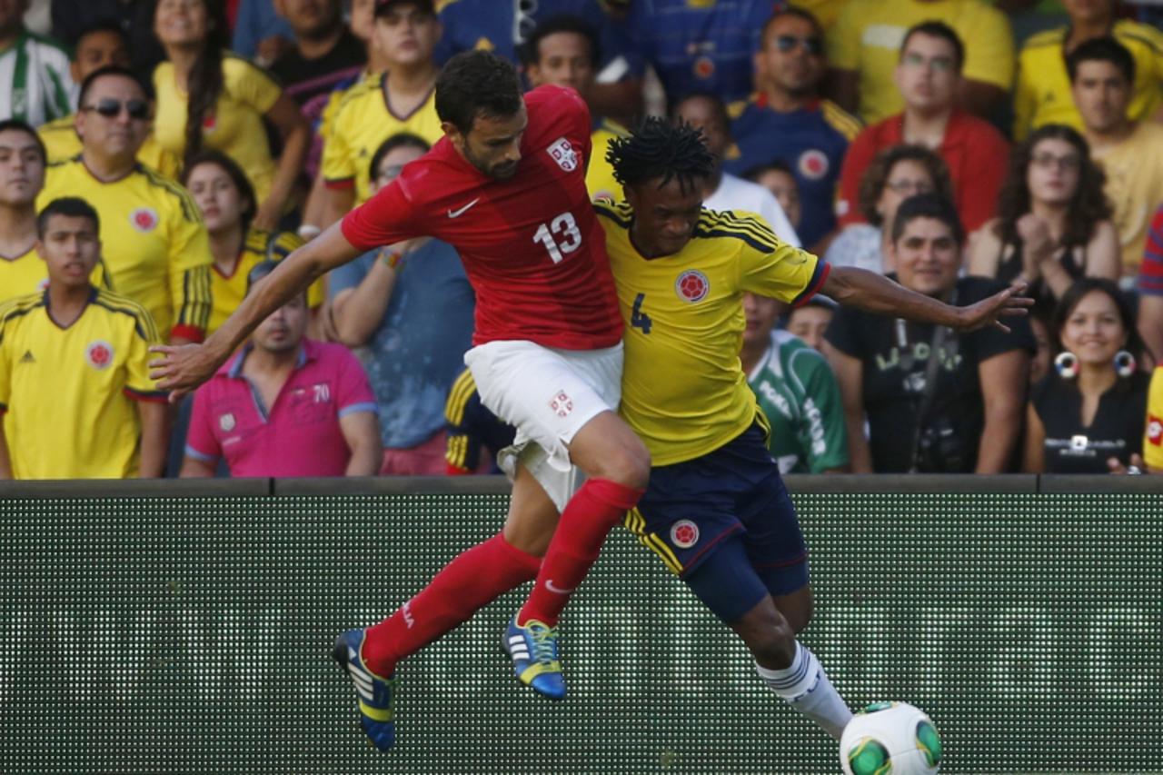 'Colombia\'s Juan Cuadrado (4) fights for the ball against Serbia\'s Ivan Radovanovic during their international friendly soccer match at Mini-Estadi stadium in Barcelona. REUTERS/Albert Gea (SPAIN - 
