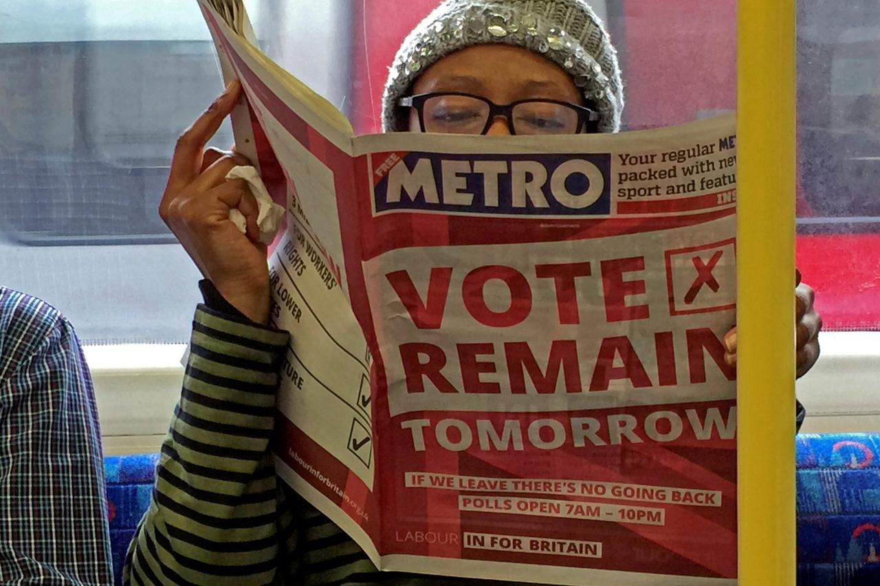 REFILE - ENHANCING QUALITY A woman reads a newspaper on the underground in London with a 'vote remain' advert for the BREXIT referendum, Britain June 22, 2016. REUTERS/Russell Boyce 