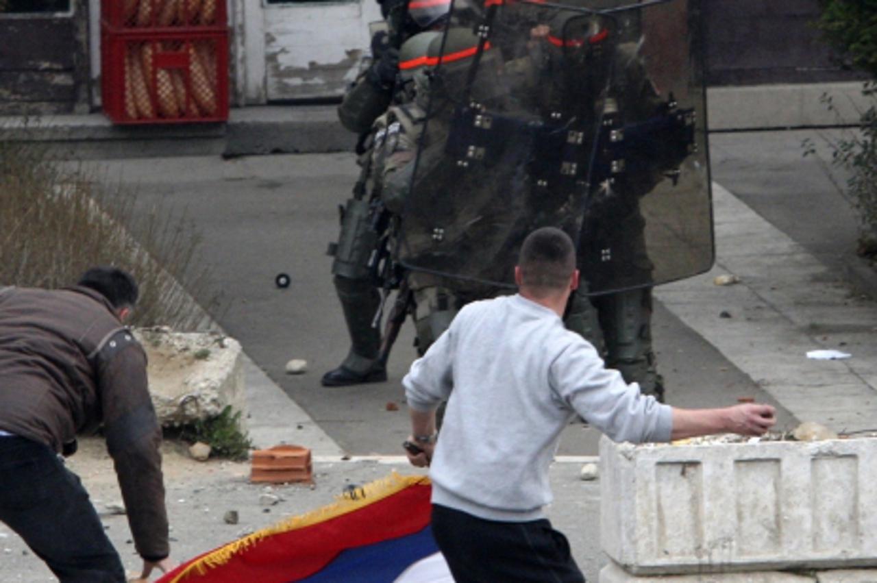 'A Serb protester throws a stone at French NATO peacekeeping troops during clashes in the ethnically divided city of Kosovska Mitrovica March 17, 2008. Serbs attacked a U.N. convoy carrying Serb detai