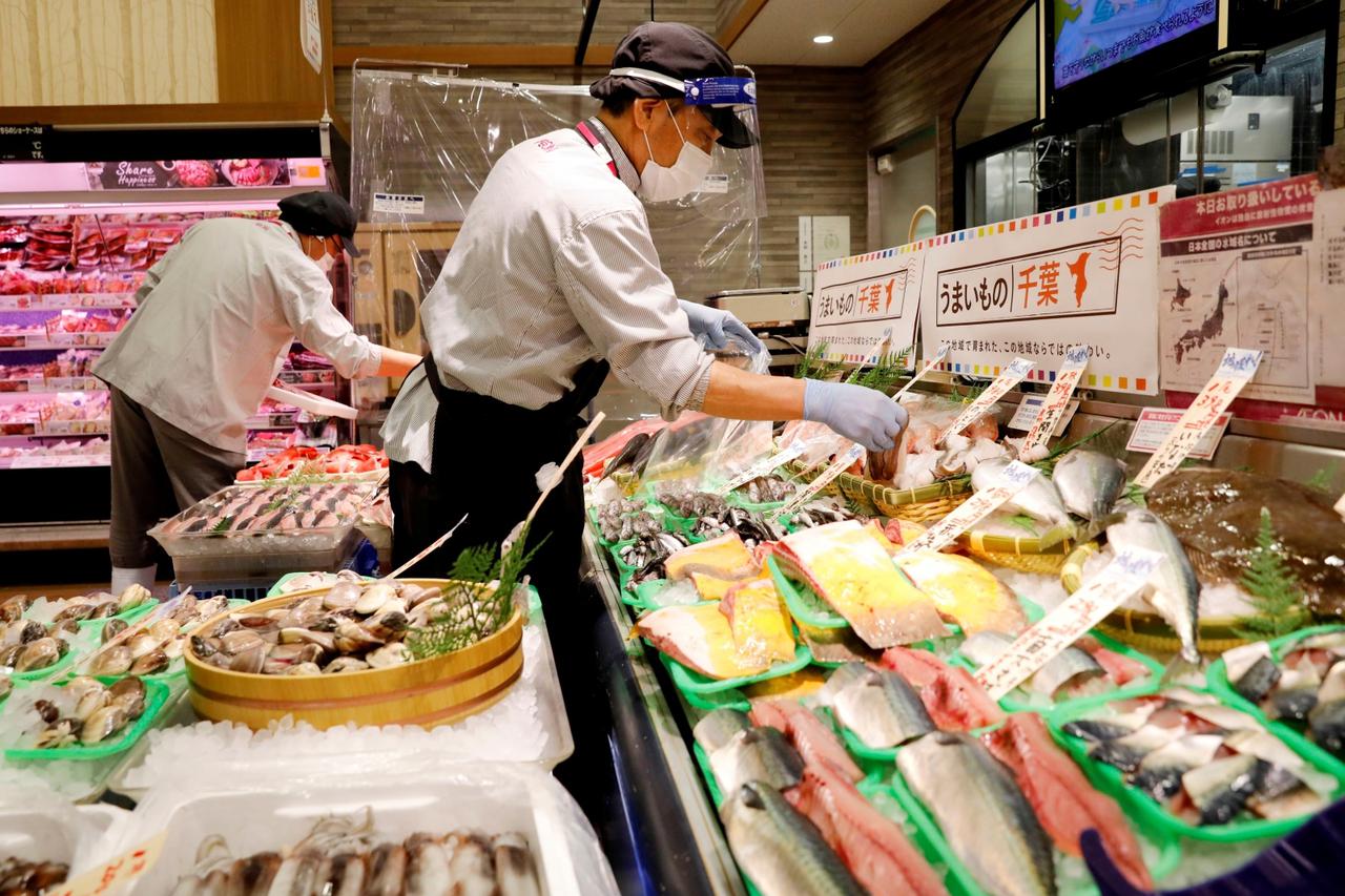 A staff wearing a face shield sells fish at Japan's supermarket group Aeon's shopping mall as the mall reopens amid the coronavirus disease (COVID-19) outbreak in Chiba