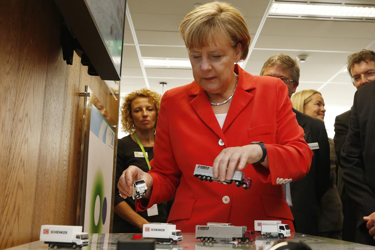 Germany's Chancellor Angela Merkel plays with models of trucks during an interactive demonstration of transportation logistics during her visit to the Future Logistics Living Lab in Sydney, November 17, 2014. Merkel is in Sydney following the G20 leaders 