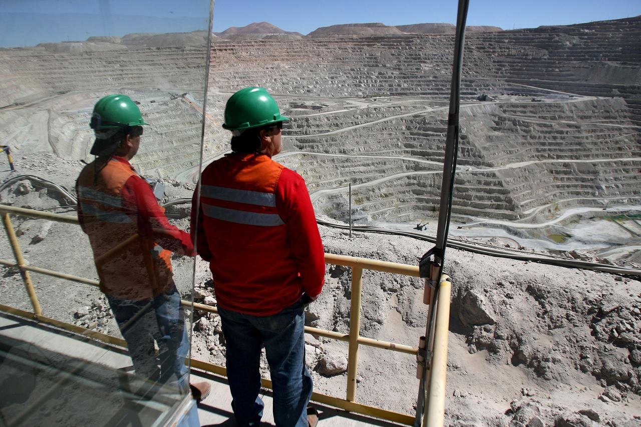 FILE PHOTO: Workers of BHP Billiton's Escondida, the world's biggest copper mine, are seen in front of the open pit, in Antofagasta,