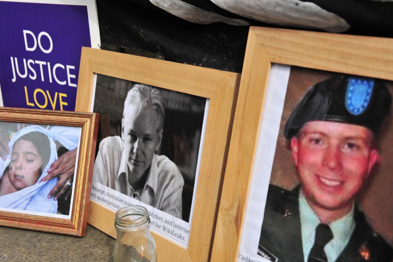 '(FILES) In this dated July 12, 2011 filed photo shows supporters of Wikileaks founder Julian Assange display photographs of Assange (C) and US serviceman Bradley Manning (R) outside the High Court in