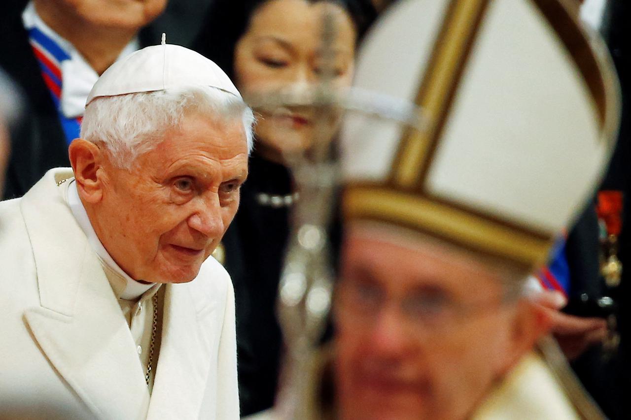 FILE PHOTO: Emeritus Pope Benedict XVI looks on as Pope Francis arrives to lead a mass to create 20 new cardinals during a ceremony in St. Peter's Basilica at the Vatican