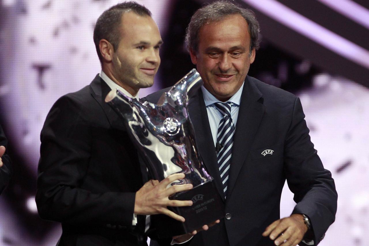 'REFILE - CORRECTING TO CHAMPIONS LEAGUE DRAW, NOT EUROPA LEAGUE FC Barcelona\'s Andres Iniesta (L) of Spain receives the Best Player UEFA 2012 award from UEFA President Michel Platini during the draw