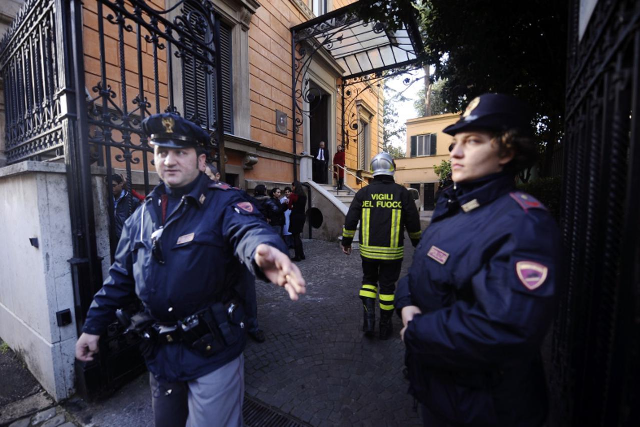 'Italian policemen control as they work at the front of the main gate of the Chilean embassy in Rome on December 23, 2010. A bomb exploded at the Chilean embassy in Rome, injuring one person, ANSA new