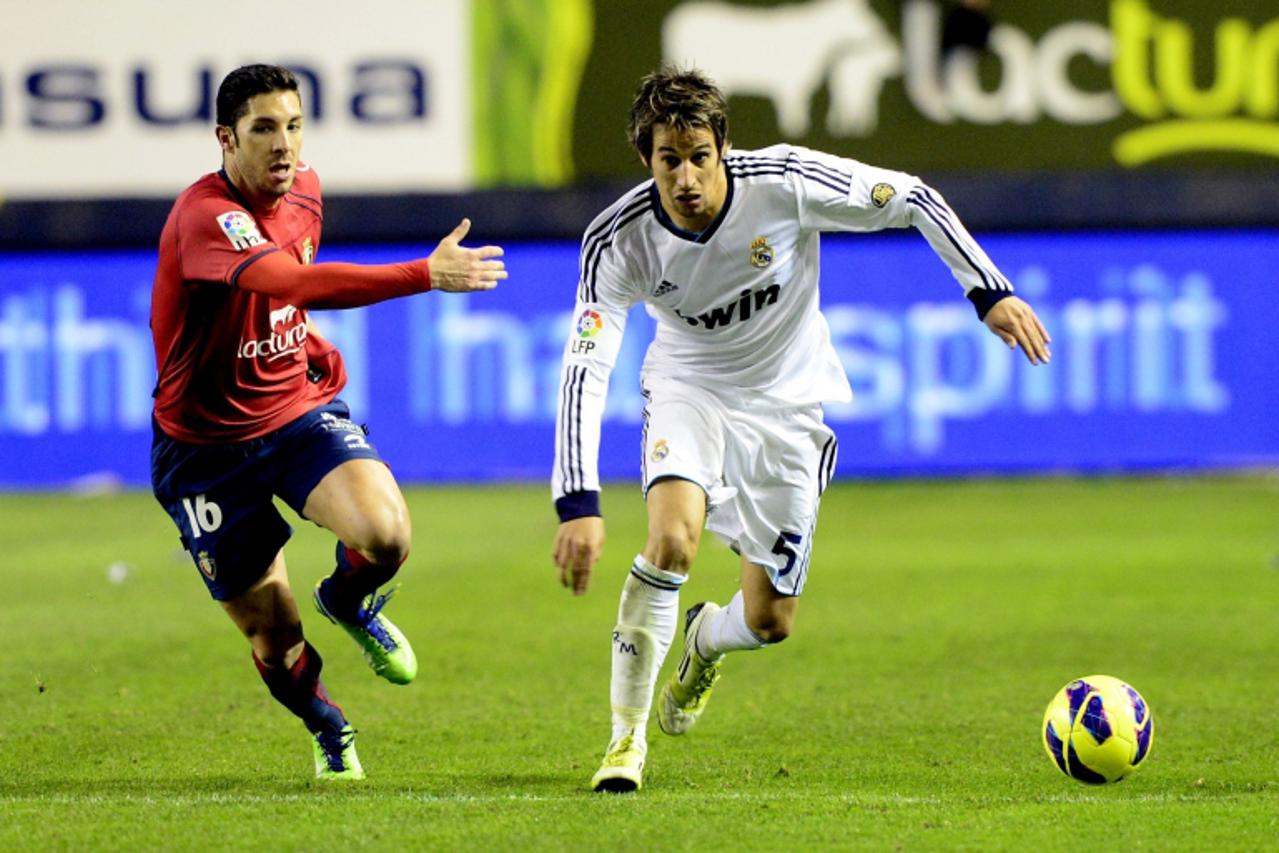'Real Madrid's Fabio Coentrao (R) fights for the ball with Osasuna's Alvaro Cejudo during their Spanish first division soccer match at Reyno de Navarra stadium in Pamplona January 12, 2013. REUTERS/