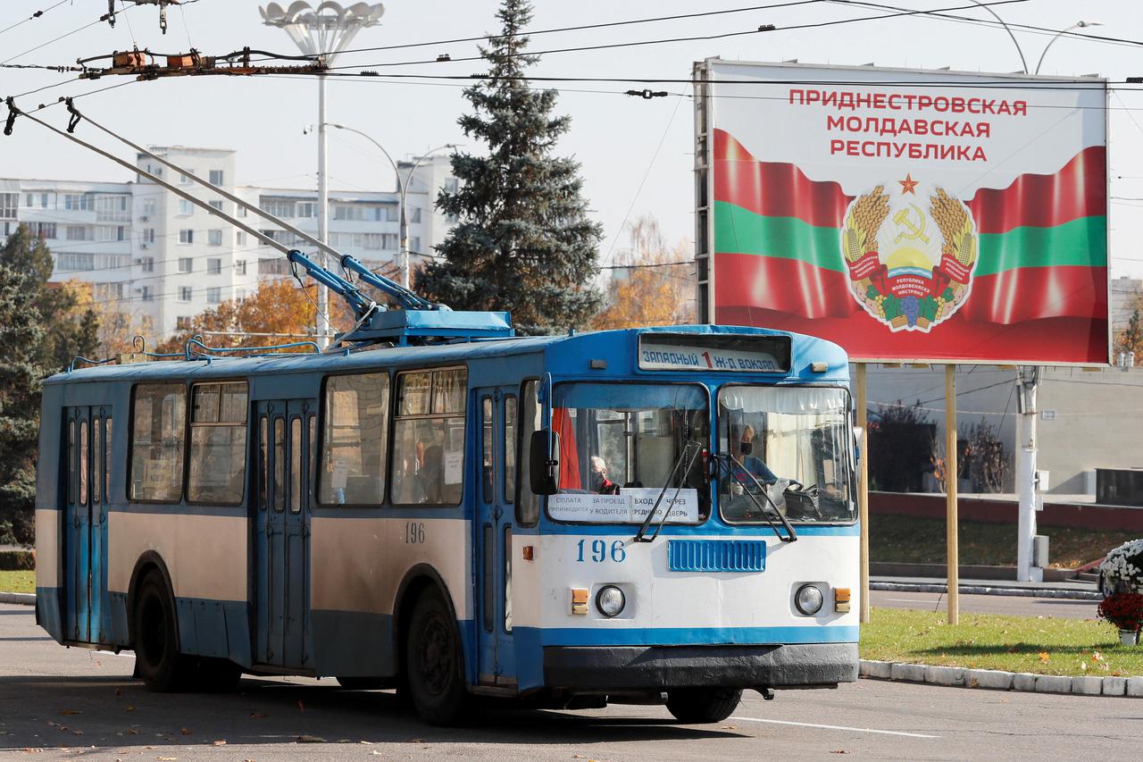 FILE PHOTO: An old trolleybus rides near a poster with the official coat of arms in Tiraspol