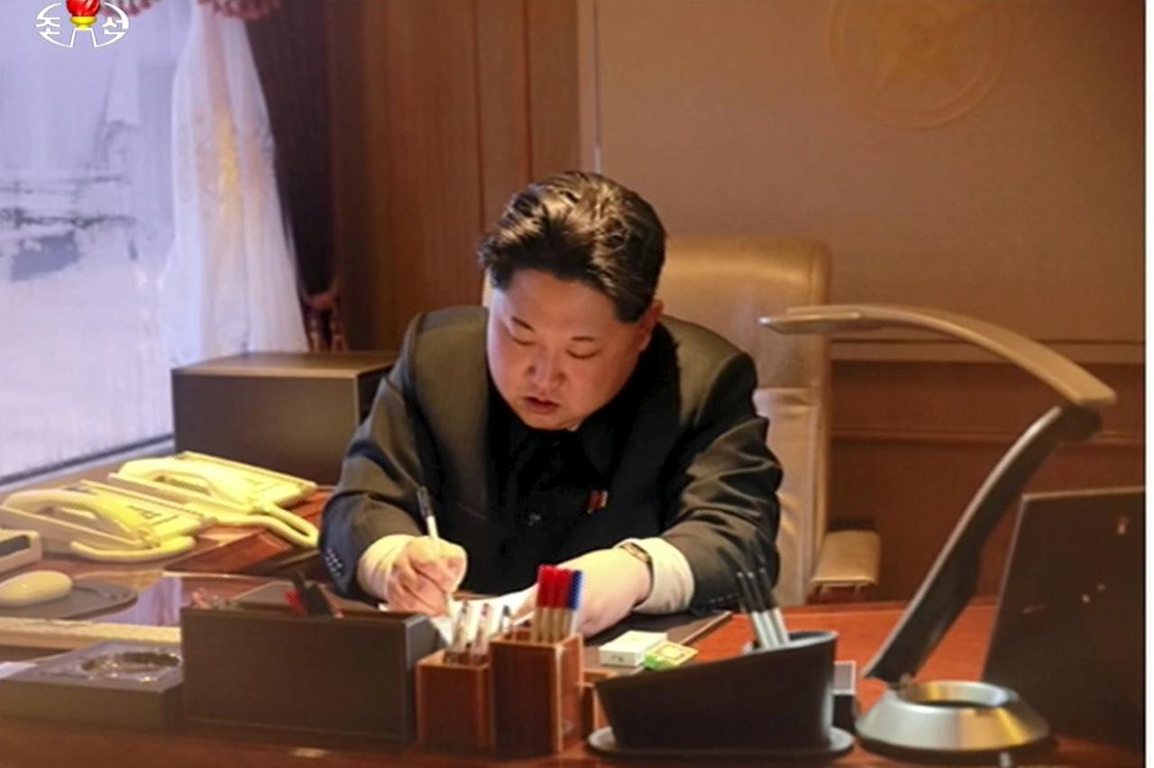 North Korean leader Kim Jong Un signs a document regarding a long range rocket launch in this still image taken from KRT footage and released by Yonhap on February 7, 2016.  REUTERS/Yonhap ATTENTION EDITORS - THIS PICTURE WAS PROVIDED BY A THIRD PARTY. RE