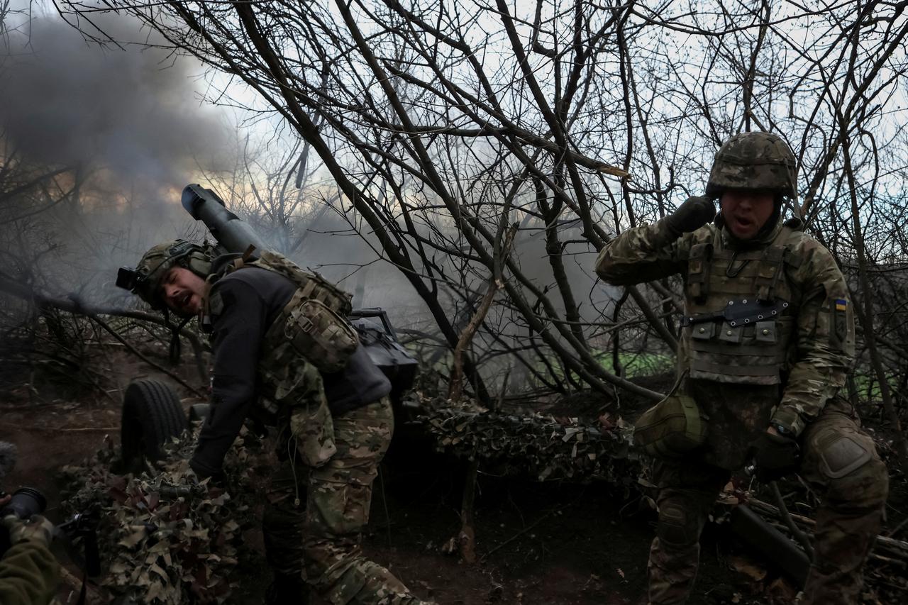Servicemen of the National Guard of Ukraine fire a howitzer towards Russian troops in Donetsk region