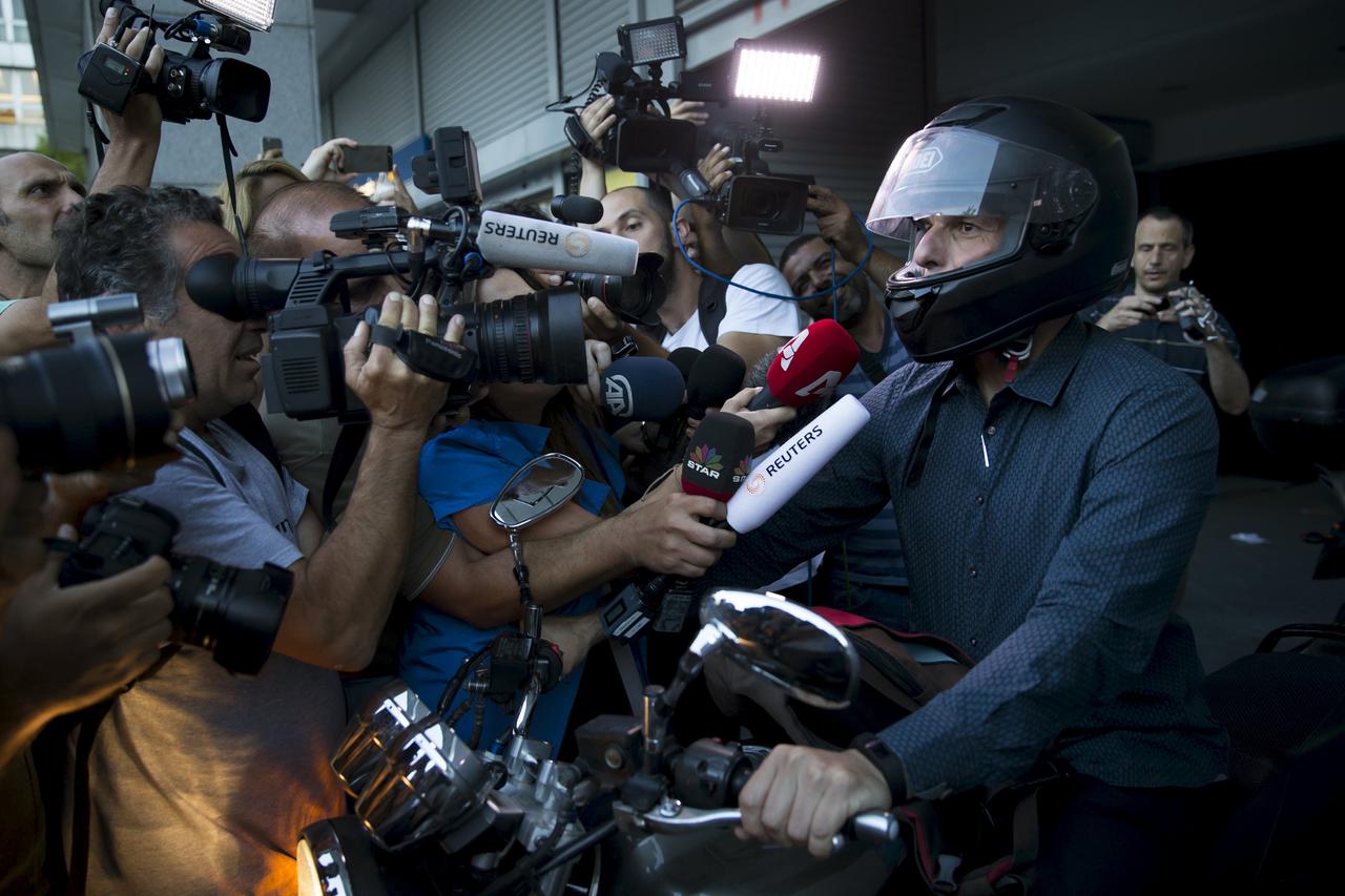 Greek Finance Minister Yanis Varoufakis talks to the media as he leaves the Finance Ministry building on his motorbike in Athens, Greece, July 1, 2015. A defiant Prime Minister Alexis Tsipras urged Greeks on Wednesday to reject an international bailout de
