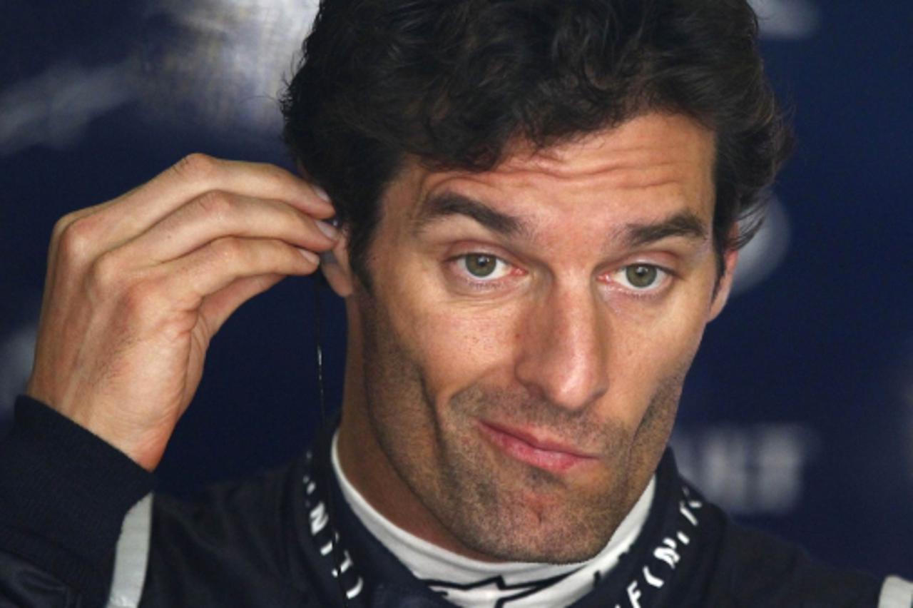 \'Red Bull Formula One driver Mark Webber of Australia adjusts his earplugs during the second practice session at the Chinese F1 Grand Prix at the Shanghai International Circuit April 15, 2011.   REUT